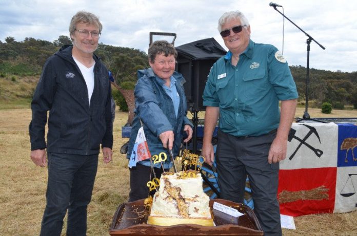 Parks Victoria manager of heritage services Paul Roser, Chewton Domain Society member Marie Jones and Parks Victoria ranger Noel Muller cut the gold themed cake created by the Chewton Phoenix CWA.