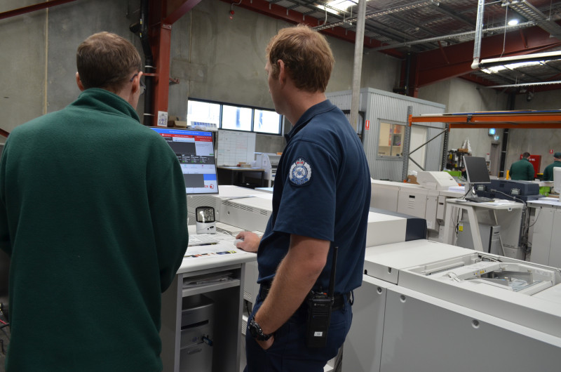 A prisoner receives instruction from a prison officer on how to use digital printing equipment as part of the VET training.