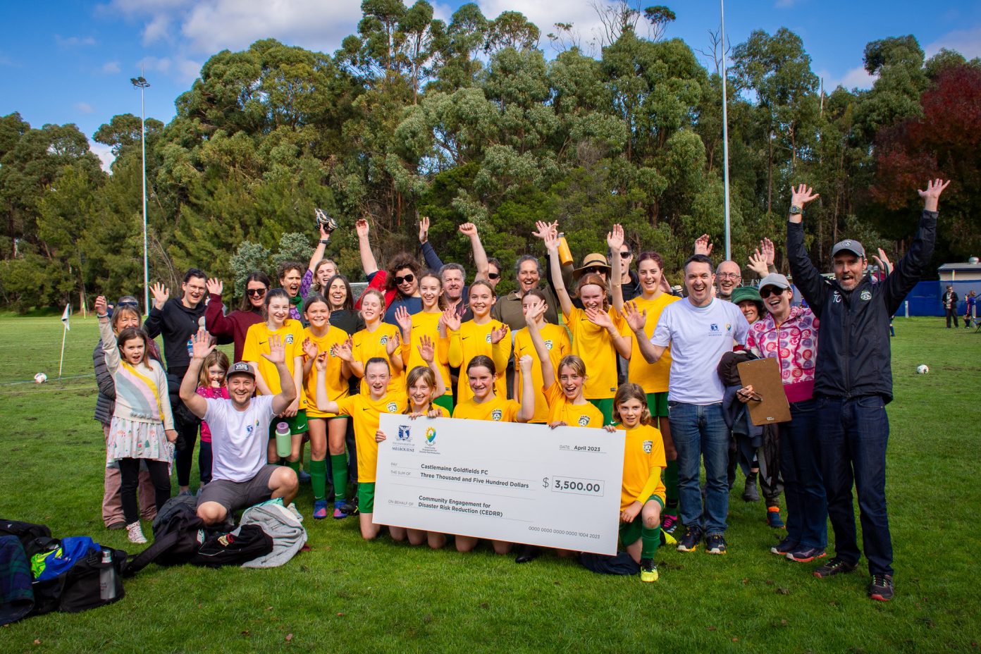 Castlemaine Goldfields Football Club members celebrate the presentation of the cheque from the University of Melbourne research team. Photo: Miranda Russell.