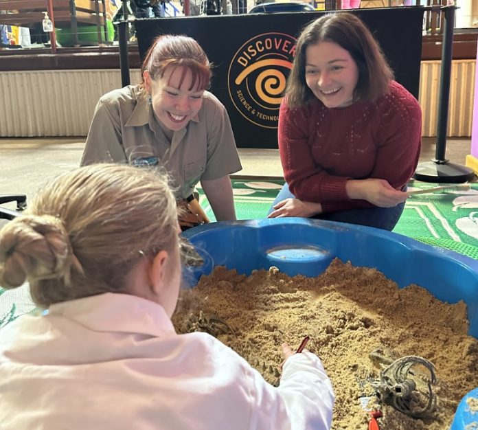 Discovery Centre general manager Alissa van Soest and Lisa Chesters MP digging for fossils at one of the new experiences.