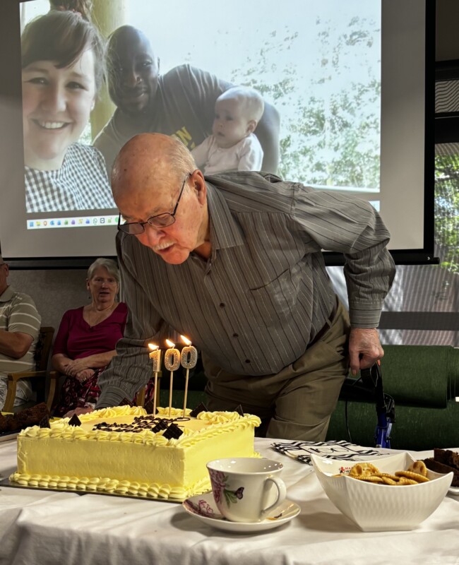 Malcolm blows out his candles as his family from Nairobi watch on.