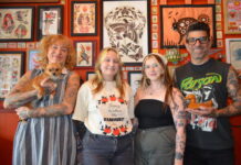 Forest Creek Tattoo owner Leonie New, with parlour mascot Rosa, and artists Alara Hakea, modelling the commemorative t-shirt, Jade Webb, and Pete Pav are among the artists donating their time to raise funds for the Harcourt Progress Association Relief Fund.