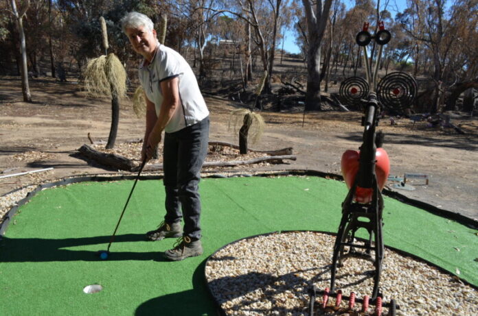 Woop Woop Mini Golf & Sculpture Gardens owner Judy Gleeson is pictured on one of the holes of the newly completed mini golf course just metres from the burnt out creek bed.