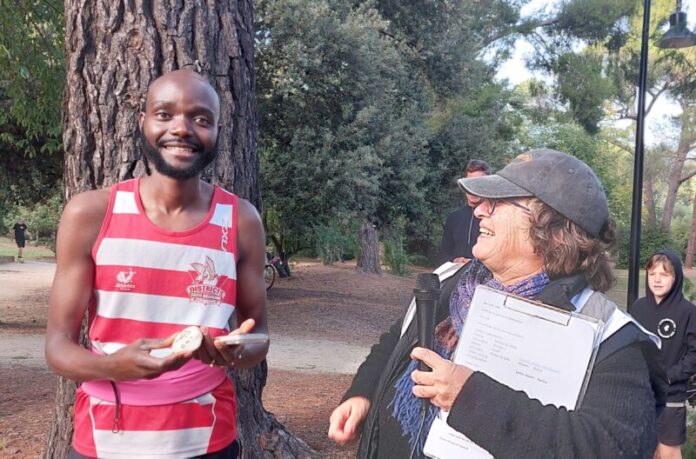 Adronis receiving his milestone momento from Run Director Jane Harding.