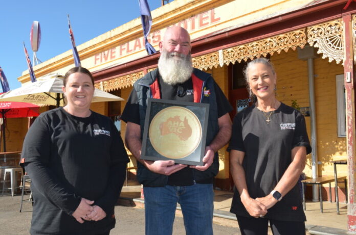Five Flags Hotel team members Renee Taylor, owner Paul Kelly, and Anita Berns celebrate their latest win.