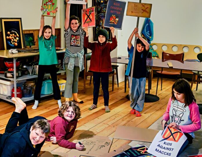 Kids Against Maccas participants prepare for the rally on Wednesday evening.