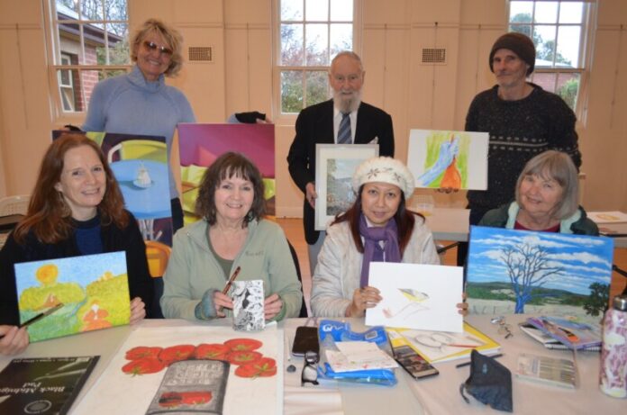 Some of the Agitation Hill Artists members Julie, Irma, Mandy, Chris, Suki, Gary and Catherine prepare for their July exhibition.