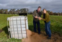 Community backs itself with $100,000 for home-grown organics plan Local farmer and member of the coalition, Jarrod Coote, and Mount Alexander Organics Partnership spokesperson, Mikaela Beckley, examining the cows' feed of spent brewery grain sourced from Love Shack. Photo: Jade Jungwirth