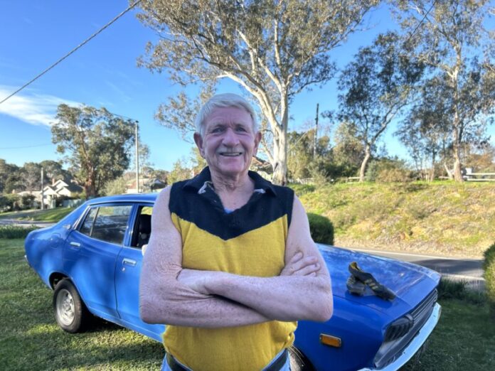 Jack with his '75 Datsun with his boots that he wore in the '75 game on the hood, with mud left over from his last ever game.