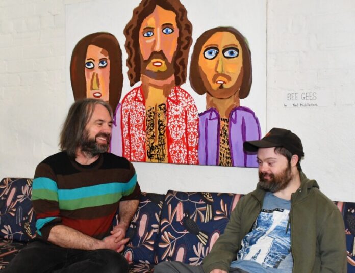 Ned (right) with fellow artist Simon Dubbeld in front of his painting of the Bee Gees.