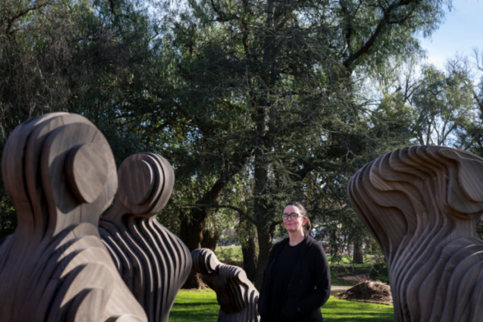 Artist Laura Woodward with her public artwork, Wildflowers. Photo: Penny Ryan.
