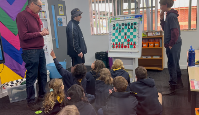 CSC teacher Mark Johansson, together with student mentors Edward Harris and Michael Miles, introducing Campbells Creek Primary School students to the mysteries of the opening moves.