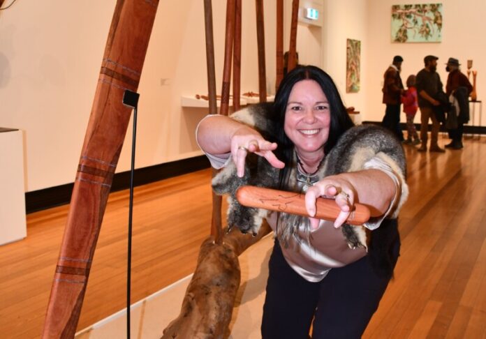 A new exhibition at Castlemaine Art Museum honours the Guildford Biyal (Red Gum) with works created from the large limb that fell in 2024 - a pivotal event for Dja Dja Wurrung people and the broader community. Narungga artist Sarah Jane Hall is pictured with her work Seven Sisters - Mangga Mangiardi. Photo: Jade Jungwirth.