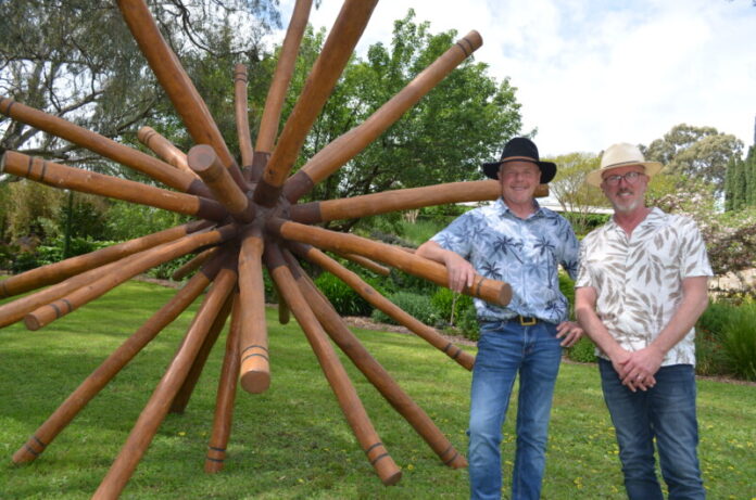 Mike Elith and Dean Swanson will be opening the gates to their stunning property 'Granite Garden' at Harcourt North. The couple are pictured with a sculpture by Mandurang artist Andrew Sardone. Photo: Lisa Dennis