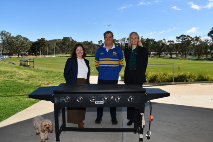 Lisa Chesters, Mark Dorian, and Lisa Harrison having a look at the club's barbecue, which is being held together with zip ties and electrical tape.
